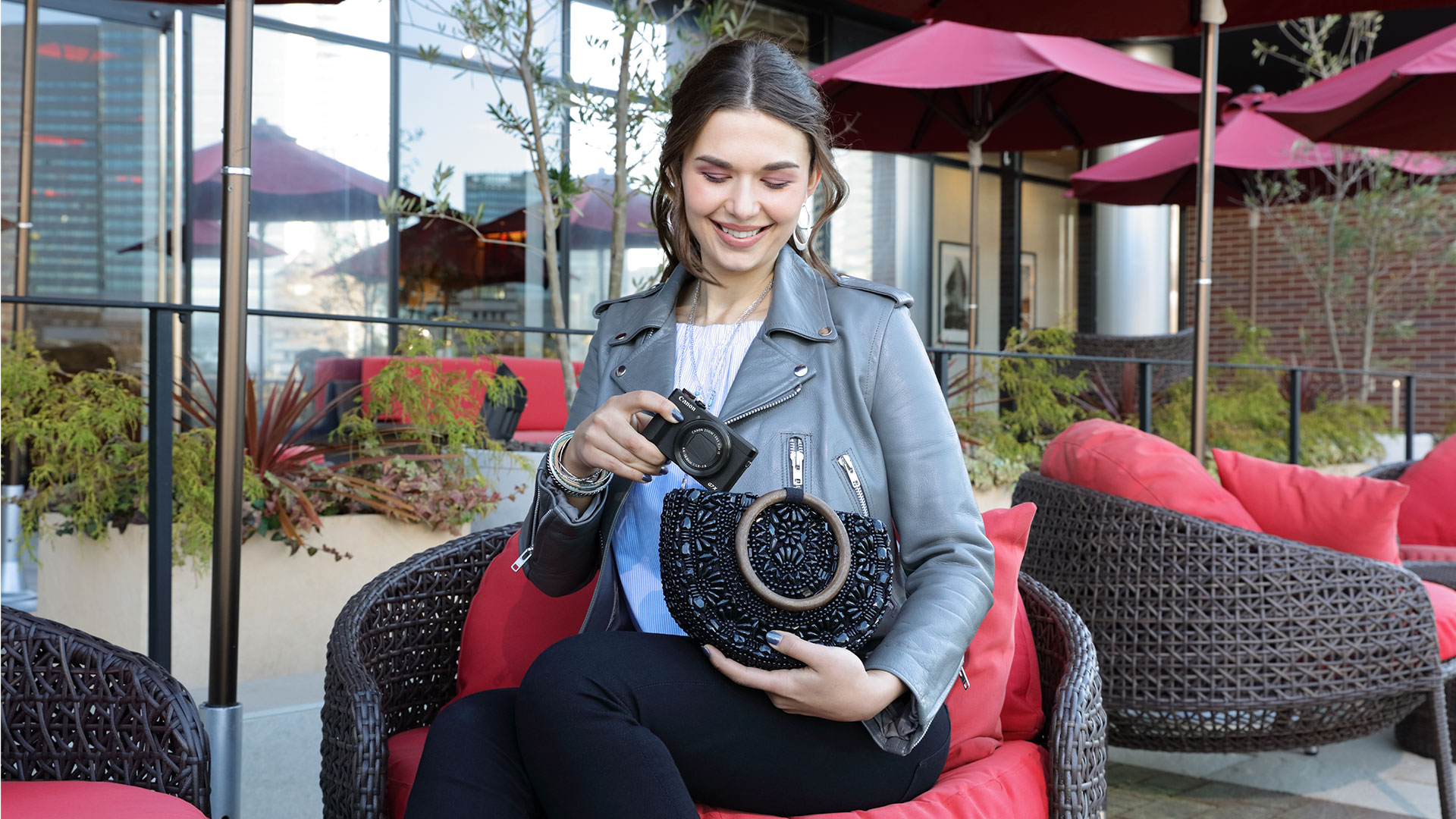 Woman holding a PowerShot G7 X Mark III in a patio