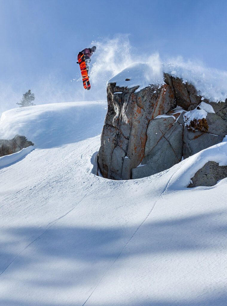 snowboarder doing a jump off a hill