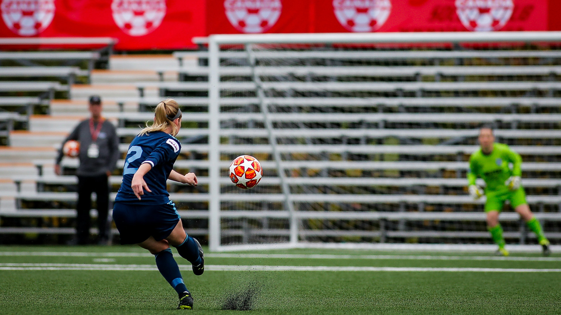 female soccer player kicking a soccer ball towards the goal
