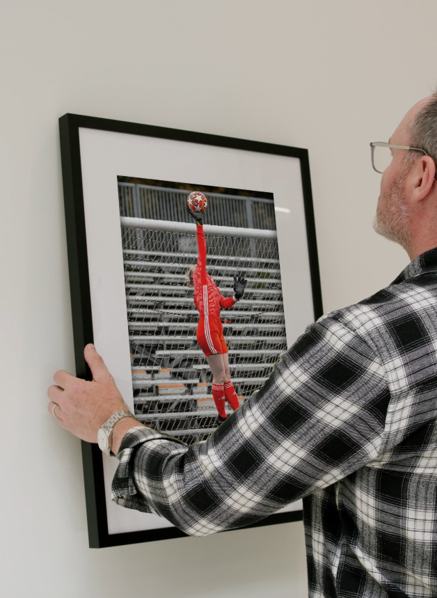 man putting a frame up of a female goalie blocking