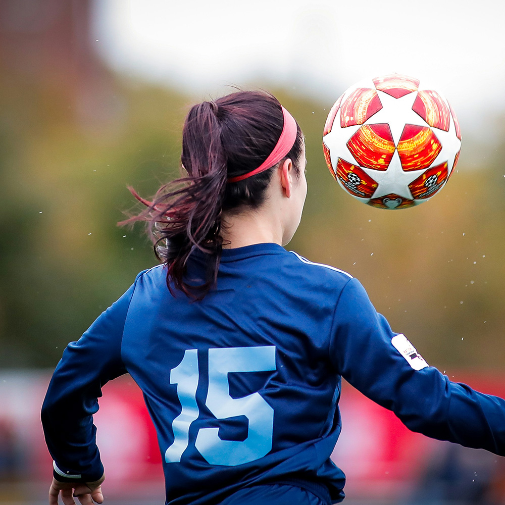 girl with a soccer ball in the air
