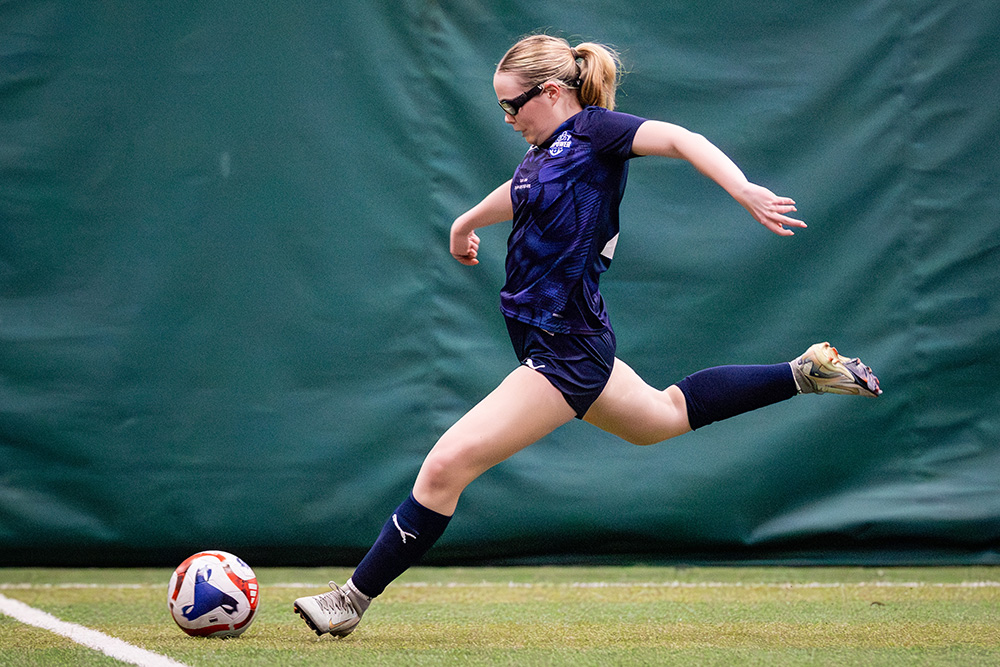 girl kkicking a soccer ball