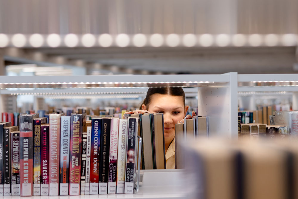 girl looking at books in a library