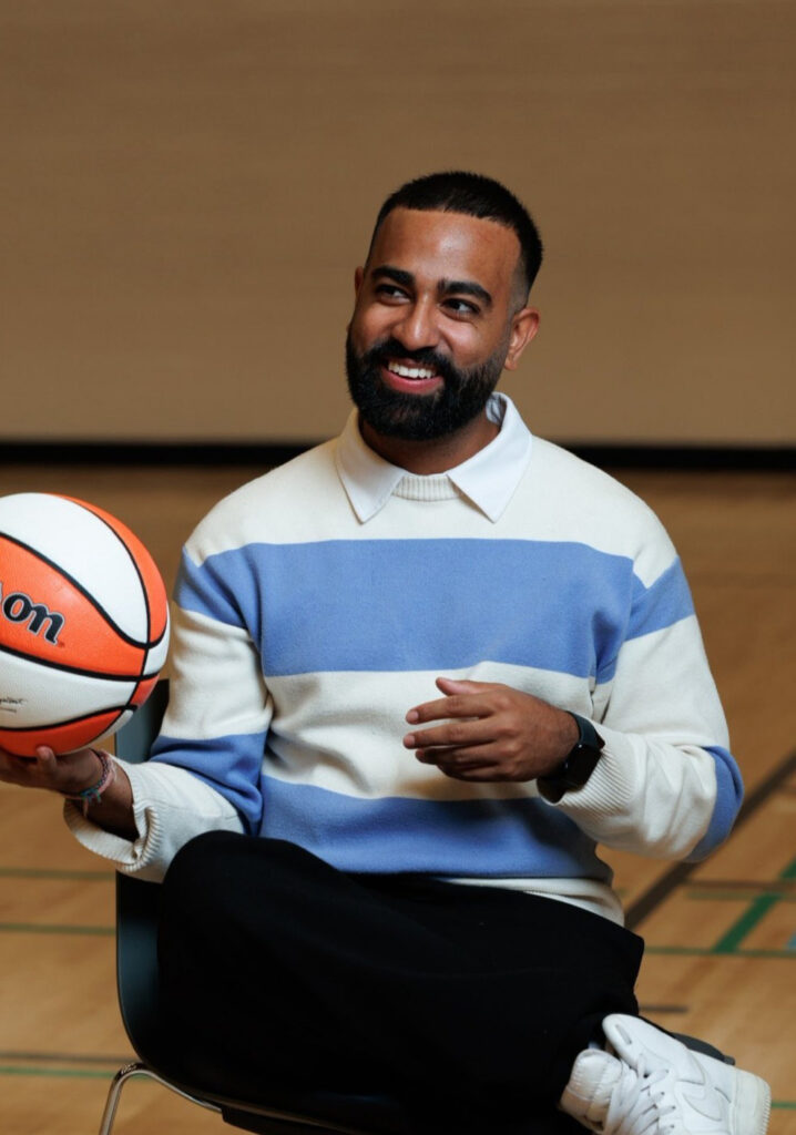 man holding a basketball sitting in a chair