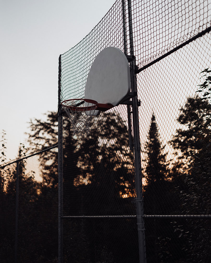 basketball hoop against a fence in the twilight