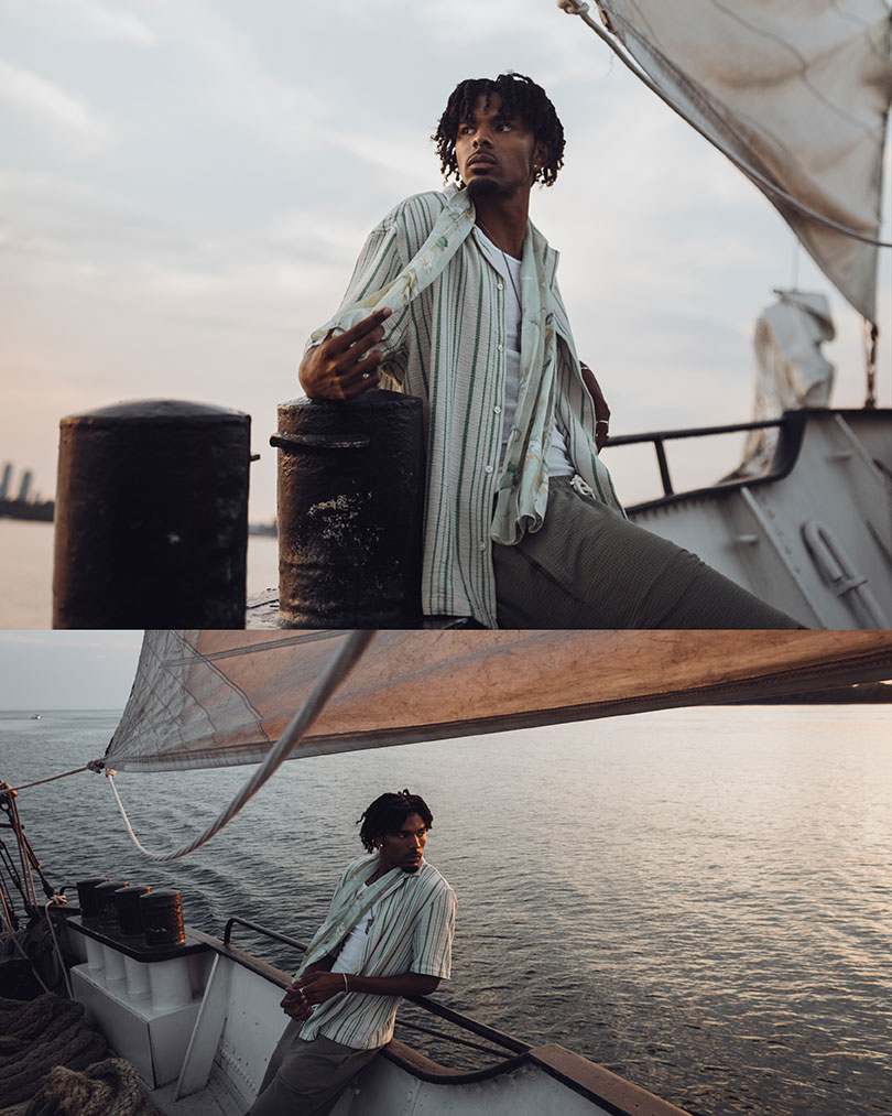 man posing against a railing  of a boat