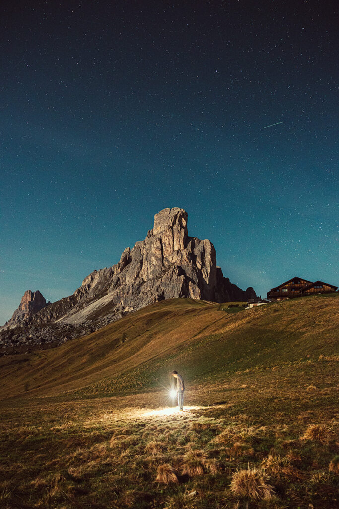 matt solie holding a light with rocky mountains and night sky in the background